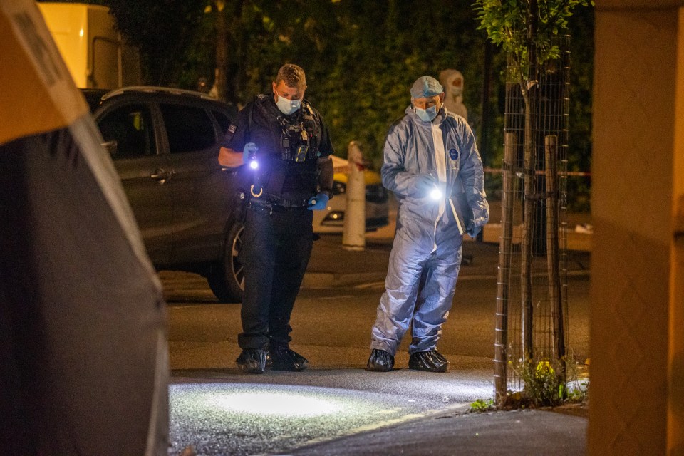 two police officers are looking for evidence in a parking lot