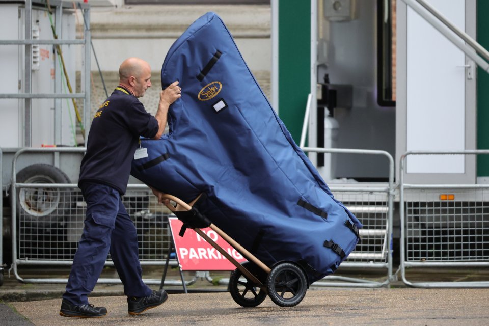 a man is pushing a large blue bag that says ' the sun ' on it