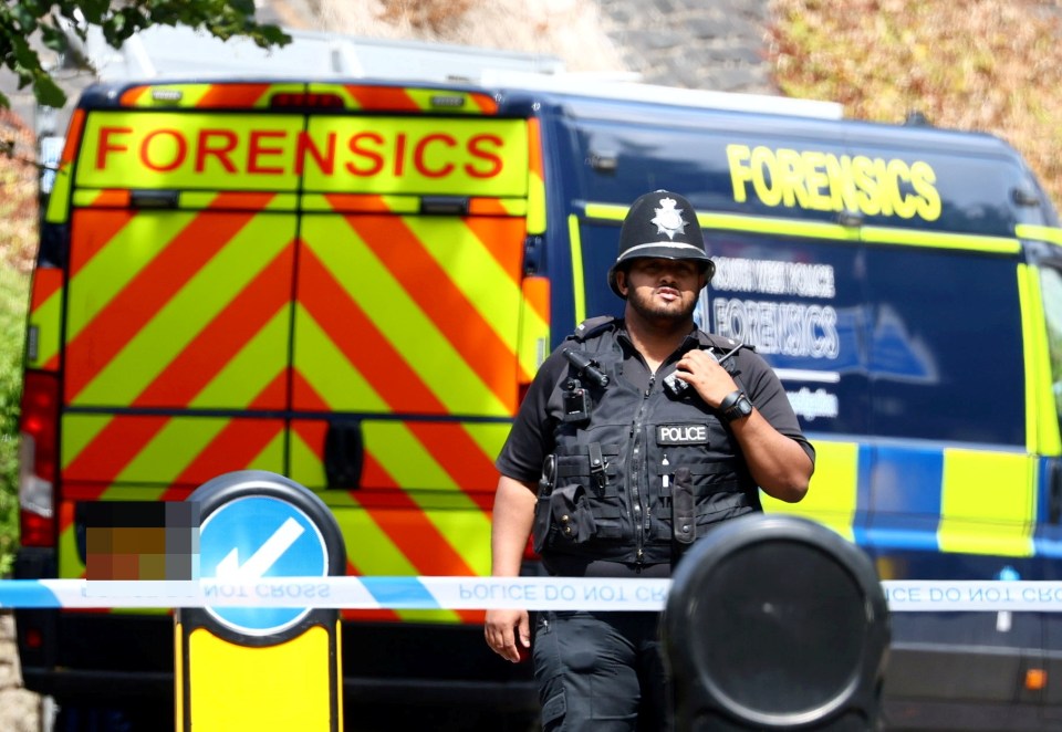 a police officer in front of a forensics van