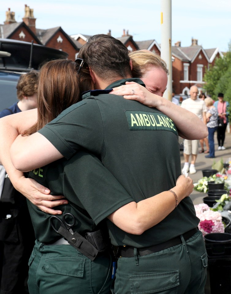 Medics comforted each other as they looked over floral tributes