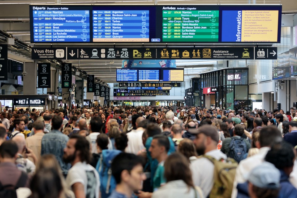 Passengers gather around the departure boards at the Gare Montparnasse train station this morning following the arson attacks