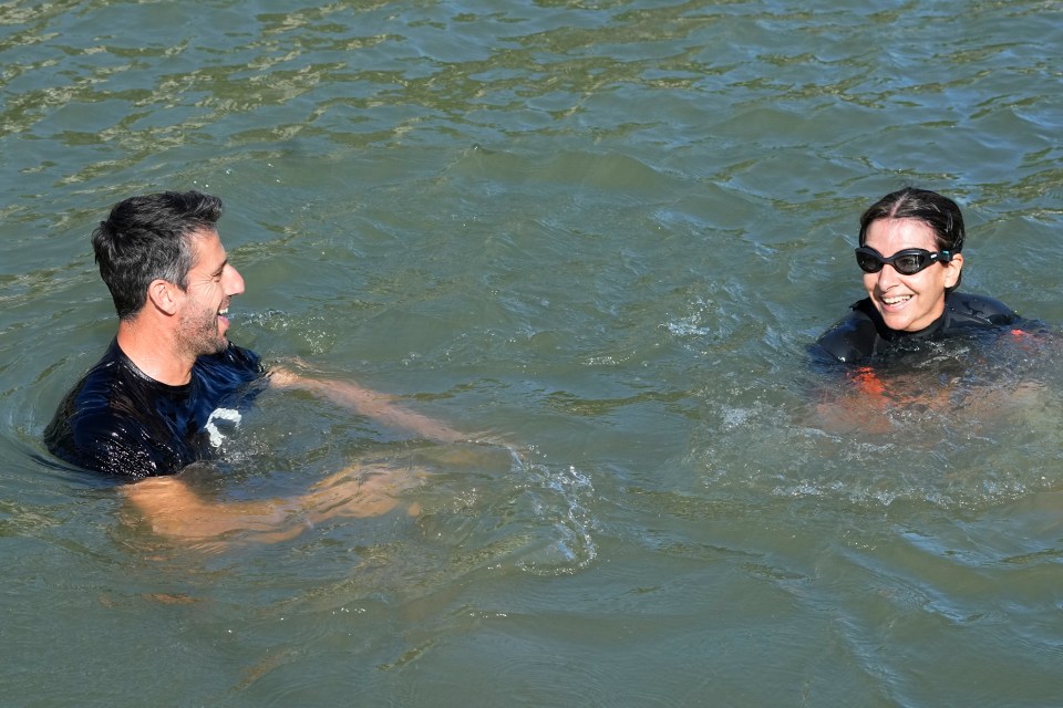 a man and a woman are swimming in a body of water