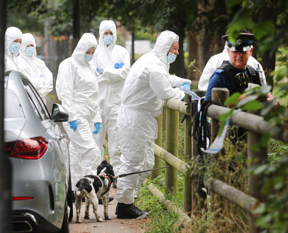 a police officer stands next to a group of people in protective suits