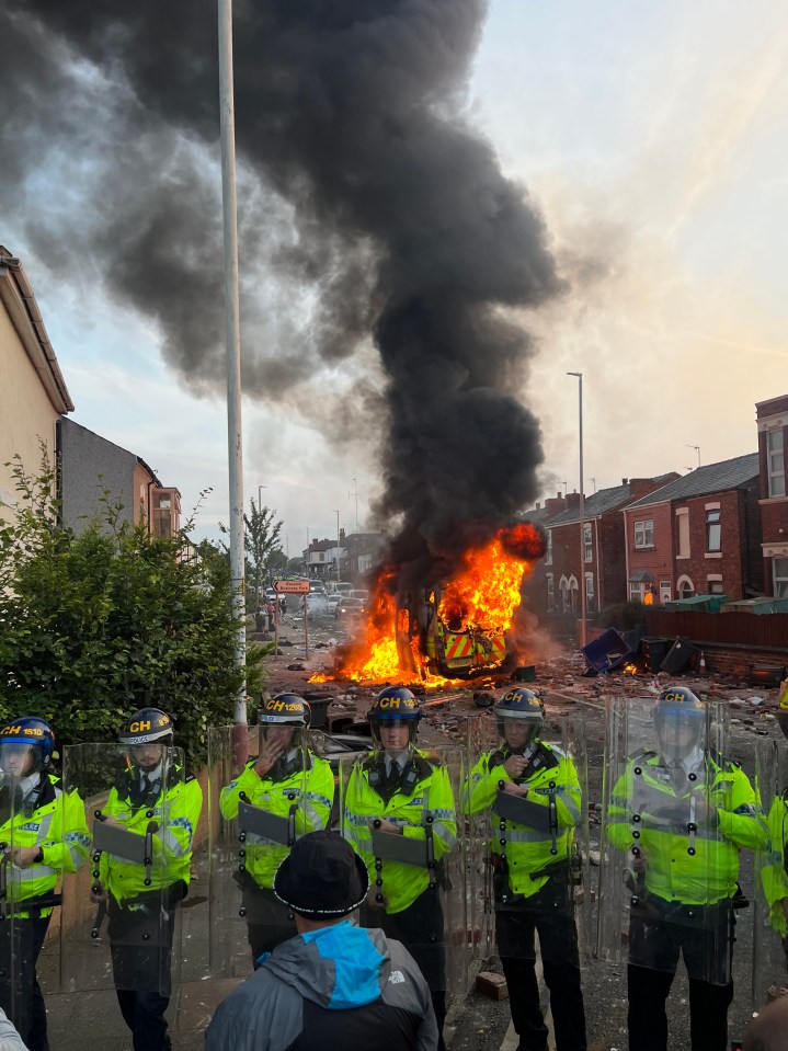 Cops stood guard with riot shields as a police van was set ablaze