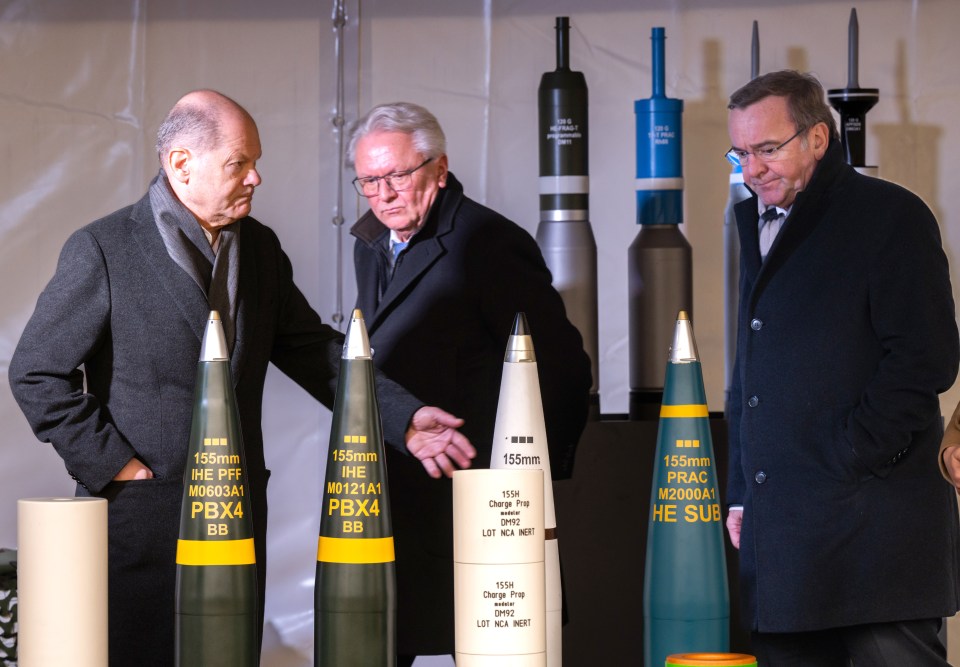 German Chancellor Olaf Scholz (left) with CEO of Rheinmetall Armin Papperger (centre) and German Defence Minister Boris Pistorius (right) with artillery ammunition