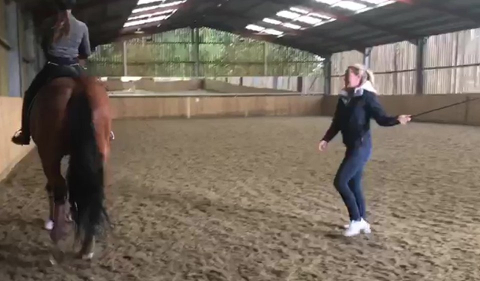 a woman riding a horse in a indoor arena