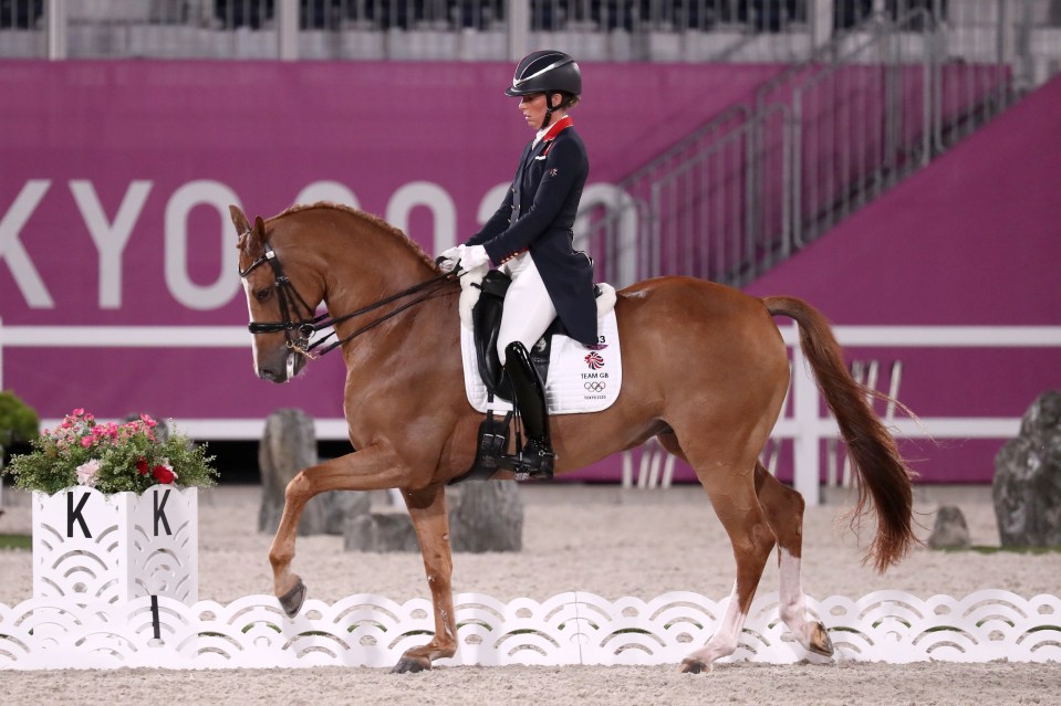 a person riding a horse in front of a sign that says kyo