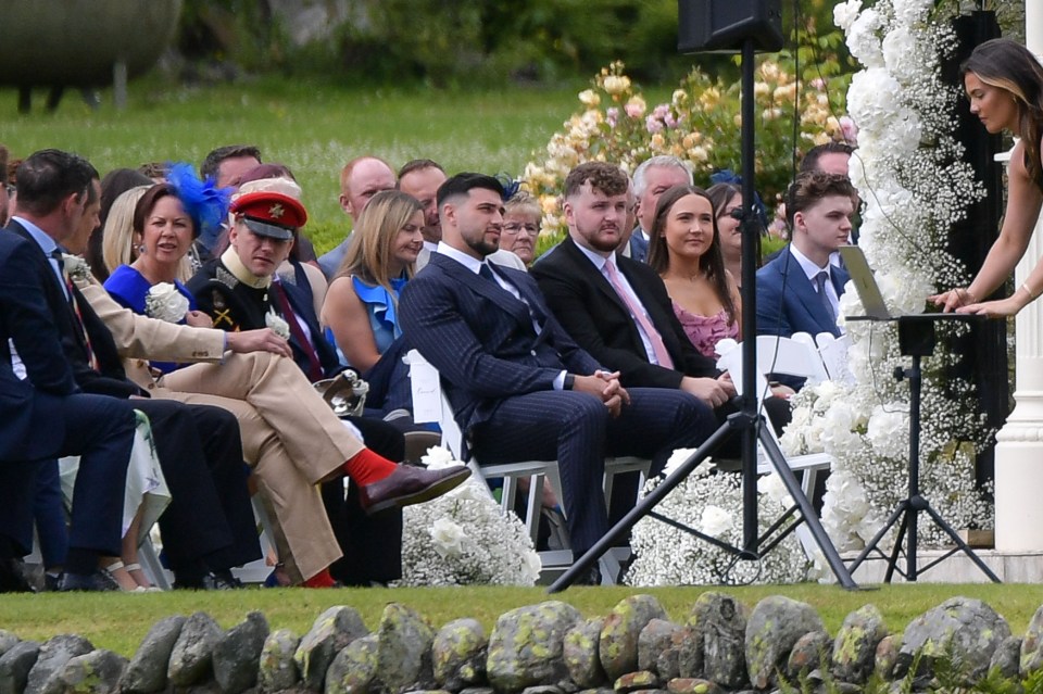 a group of people sitting in chairs at a wedding