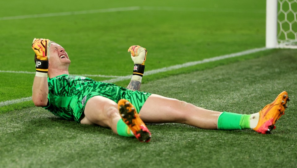 a soccer player is laying on the field with his arms in the air