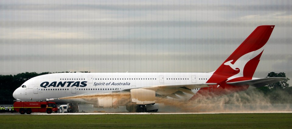 a large qantas airplane is on the runway