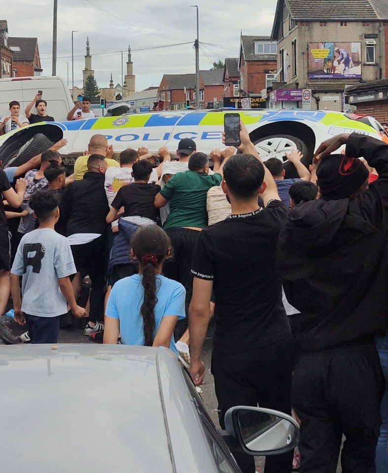 The moment the police car was overturned by rioters