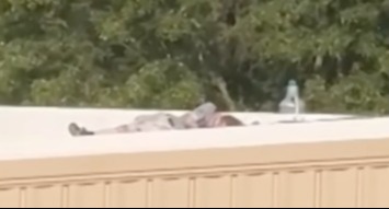 a person is laying on the roof of a building .