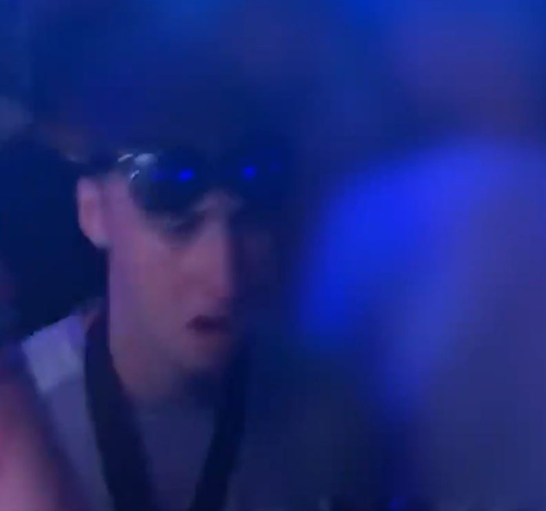 a blurry picture of a man wearing sunglasses in a dark room .