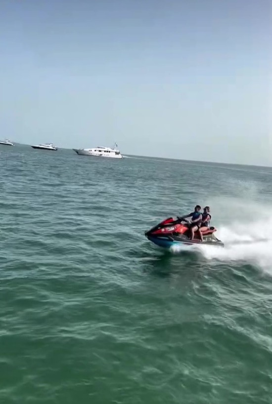 a couple of people are riding a jet ski in the ocean .