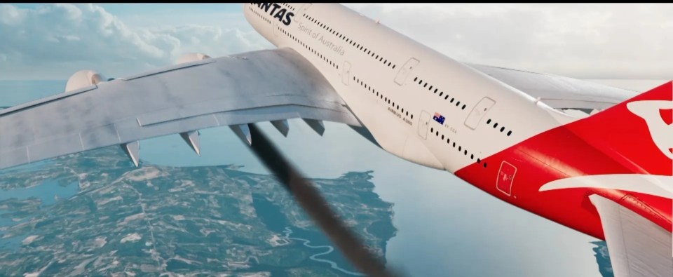 a qantas plane is flying over a body of water