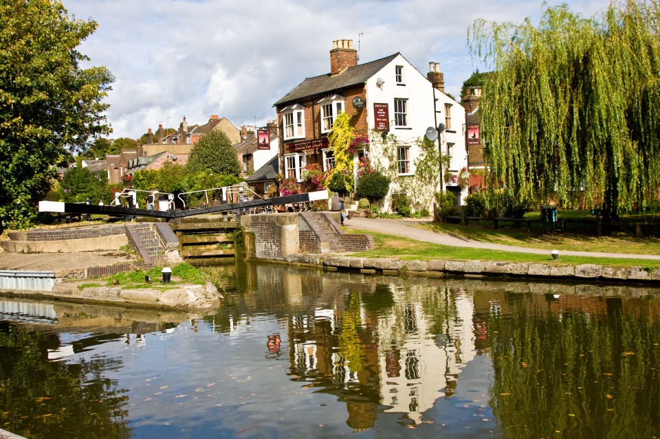 a white building with a red sign that says ' the swan inn ' on it