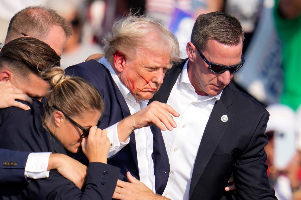 Republican presidential candidate former President Donald Trump is helped off the stage at a campaign event in Butler, Pa., on Saturday, July 13, 2024. (AP Photo/Gene J. Puskar)