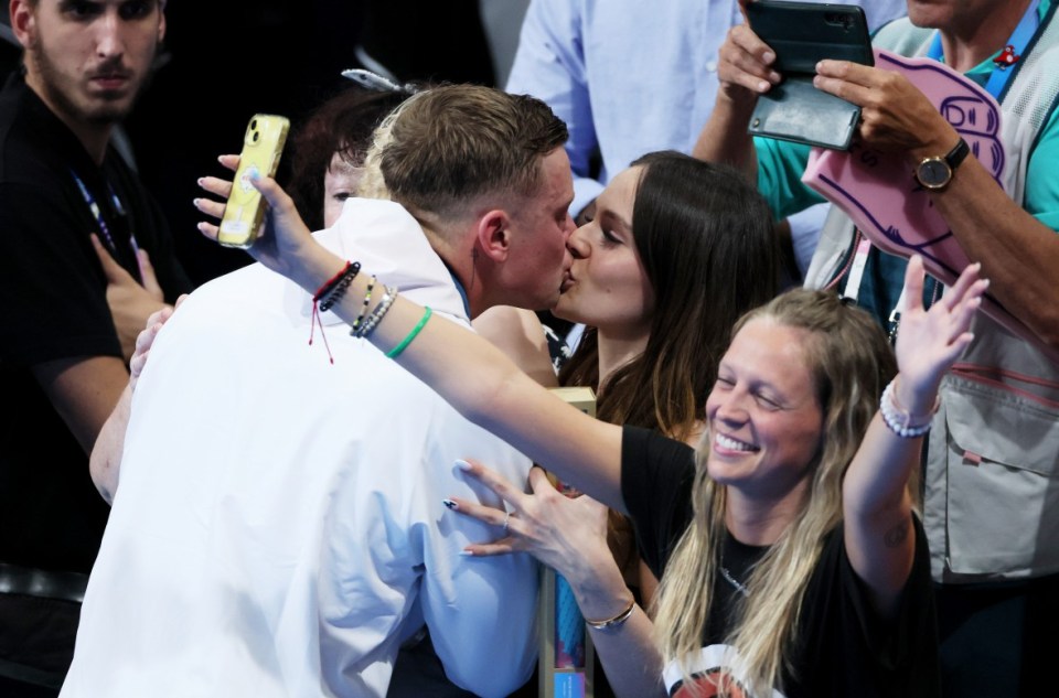 NANTERRE, FRANCE - JULY 28: Adam Peaty of Team Great Britain kisses his partner, Holly Ramsay, following the Swimming medal ceremony after the Mens 100m Breaststroke Final on day two of the Olympic Games Paris 2024 at Paris La Defense Arena on July 28, 2024 in Nanterre, France. (Photo by Clive Rose/Getty Images)