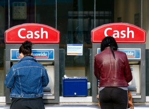 Customers use automated teller machines (ATM) outside a Nationwide Building Society branch in London, U.K., on Thursday, Nov. 24, 2011. Nationwide Building Society, the U.K.'s largest customer-owned lender, said pretax profit rose 17 percent after the company issued more mortgages and increased its consumer business through credit cards and personal loans. Photographer: Simon Dawson/Bloomberg via Getty Images