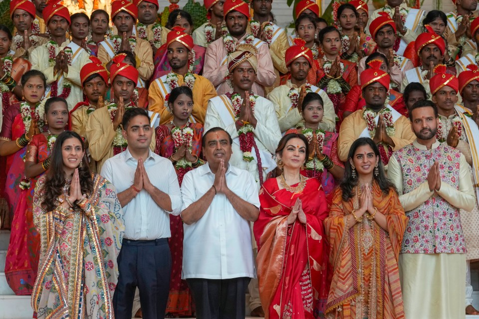 Mukesh Ambani, third left, poses with his family members at pre-wedding celebrations