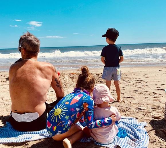 Robbie with three of his children on the beach