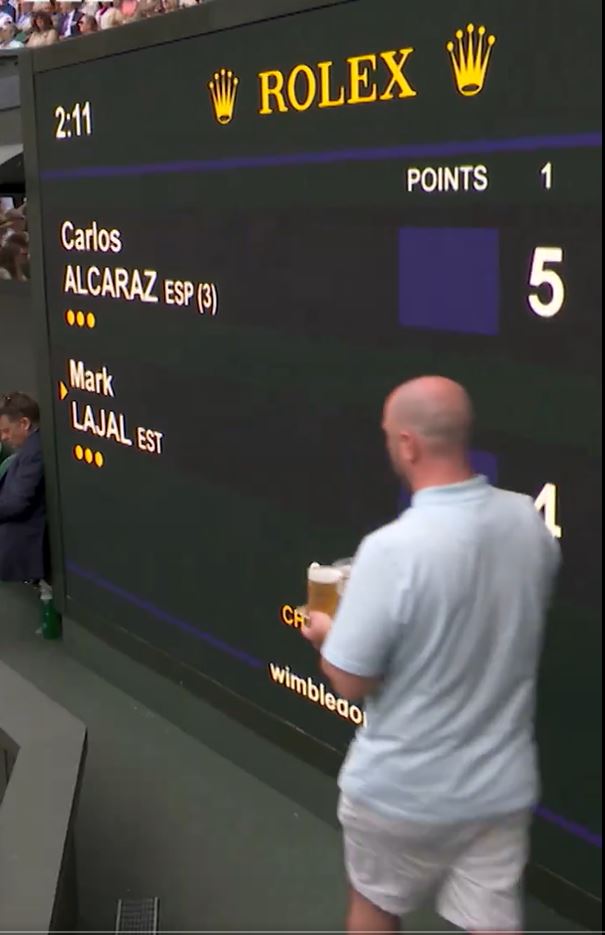 A fan clutching a four-pack walked out in front of the Centre Court scoreboard