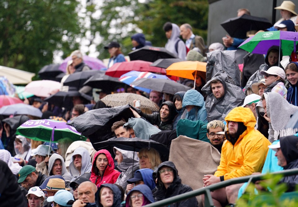 Tennis fans sheltering from the rain at Wimbledon on Tuesday