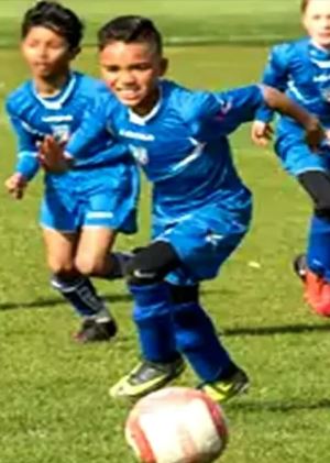 a group of young boys are playing soccer on a field .