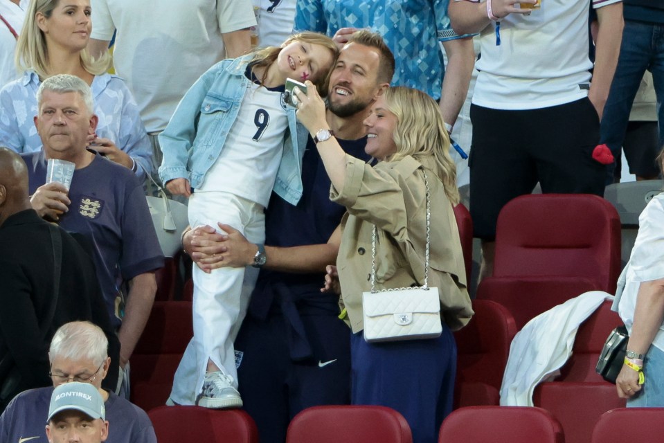 Katie Goodland with a white Chanel handbag in the stands