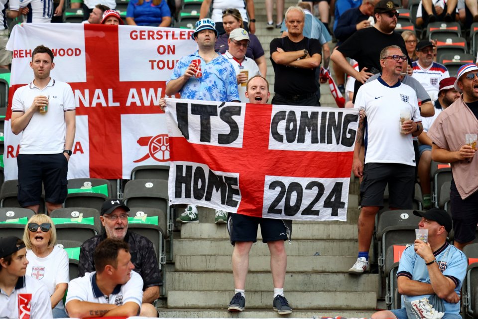 An England fan holds a flag inside the stadium before the match