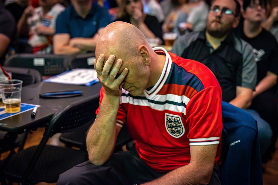 One fan holds his head in his hands at the World Matchplay Darts in Blackpool