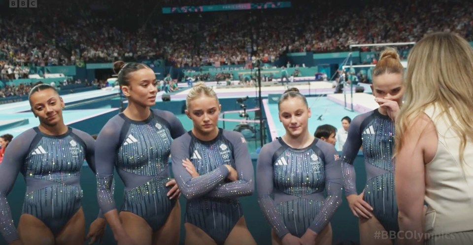 a group of female gymnasts standing next to each other with a bbc logo in the background