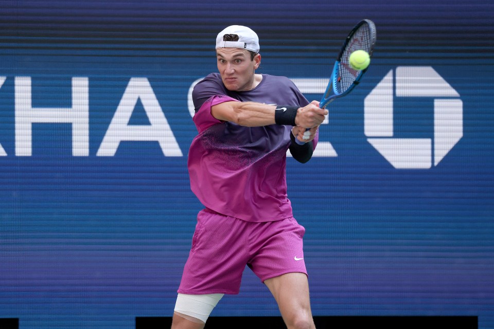 a man in a purple shirt is playing tennis