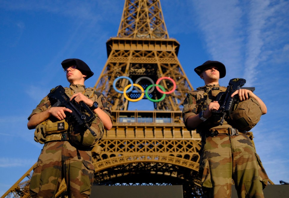 Paris 2024 Olympics - Paris 2024 Olympics Preview - Paris, France - July 21, 2024 Soldiers patrol on a street in front of the Eiffel Tower ahead of the Olympics REUTERS/Stefan Wermuth