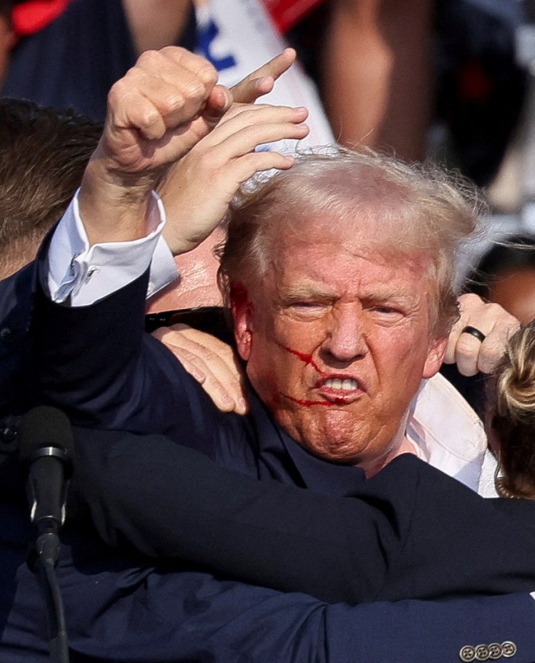 Republican presidential candidate and former U.S. President Donald Trump is assisted by the Secret Service after gunfire rang out during a campaign rally at the Butler Farm Show in Butler, Pennsylvania, U.S., July 13, 2024. REUTERS/Brendan McDermid