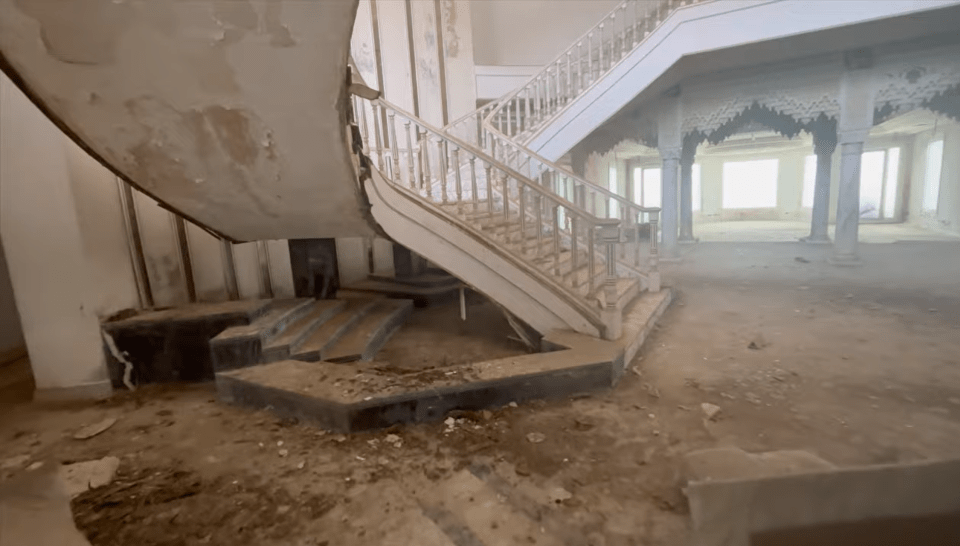 a staircase in an abandoned building with a broken railing