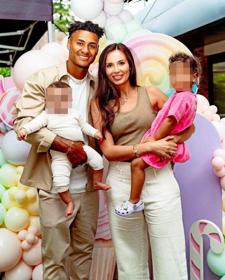 a family posing for a picture with balloons in the background