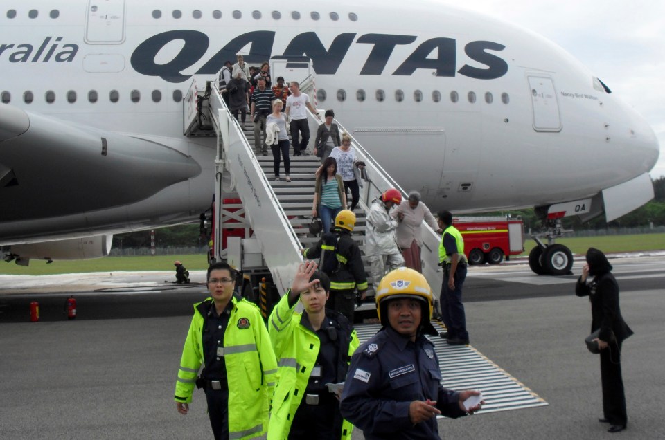 a group of people are boarding a qantas airplane