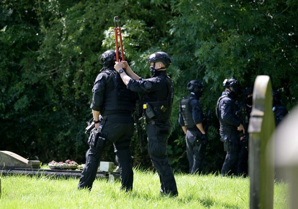 a group of police officers are in a cemetery