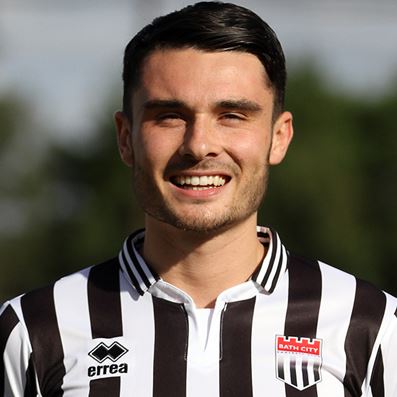 a man wearing a black and white striped jersey is smiling for the camera .