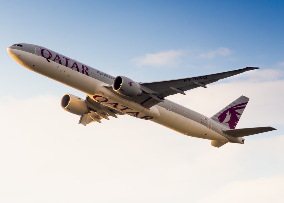 a qatar airplane is flying in the sky