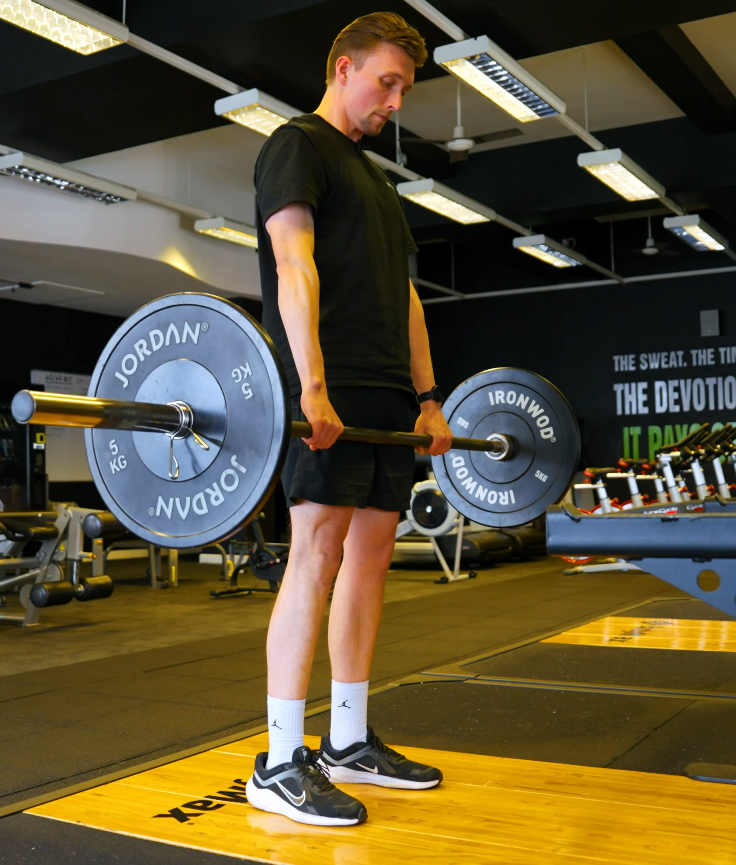 Push through your heals to come up to standing while gripping the bar