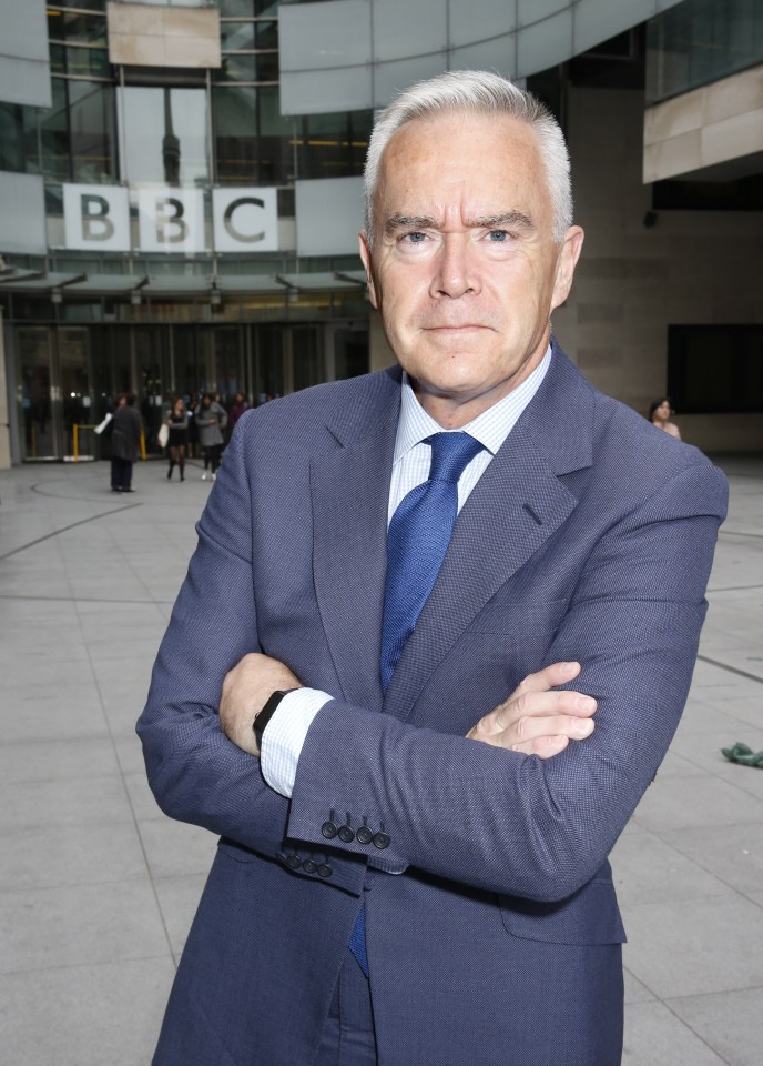 a man in a suit and tie stands in front of the bbc building