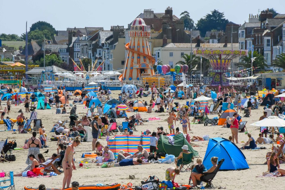 Sunbathers enjoying the scorching hot afternoon sunshine in Weymouth, Dorset