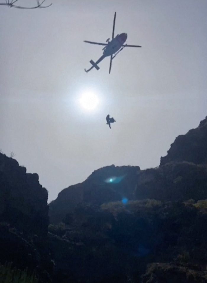 Footage shows rescue workers directing a helicopter over the mountains