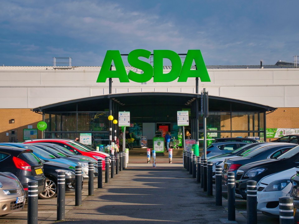 a row of cars are parked in front of an asda store