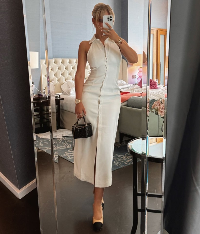 a woman in a white dress is taking a selfie in front of a mirror