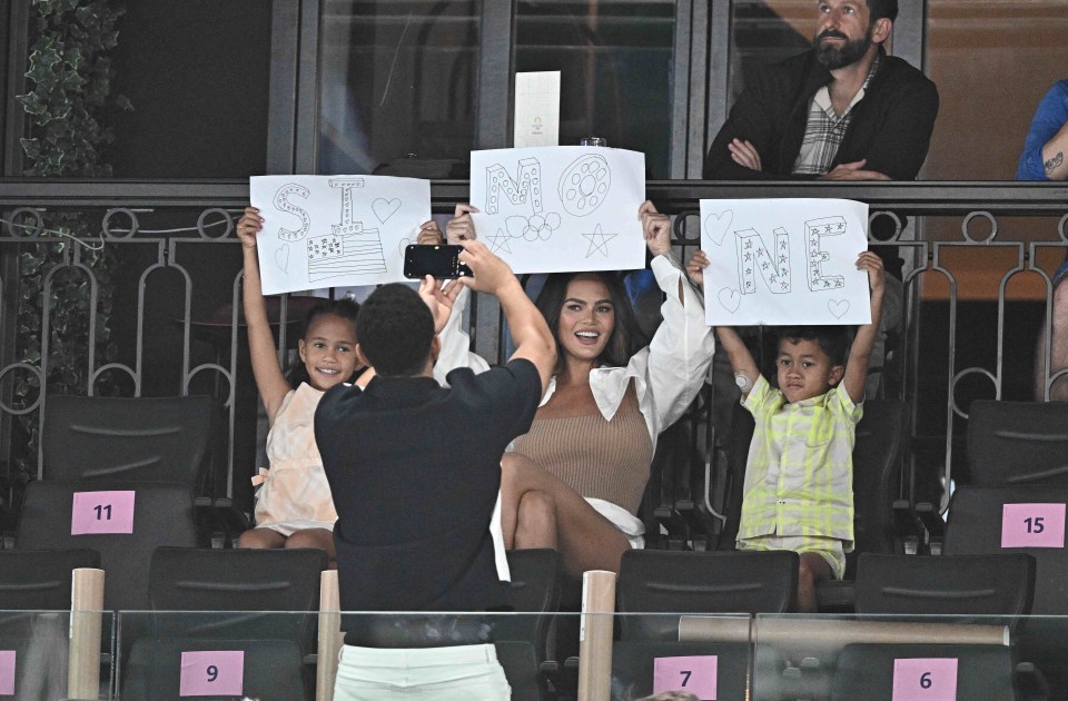 The duo and their kids came armed with home-made signs