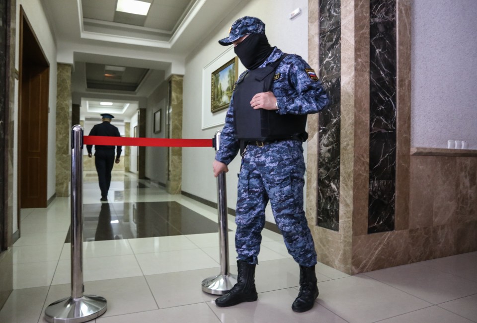 A masked guard stands outside the closed-door hearing at court in Russia today