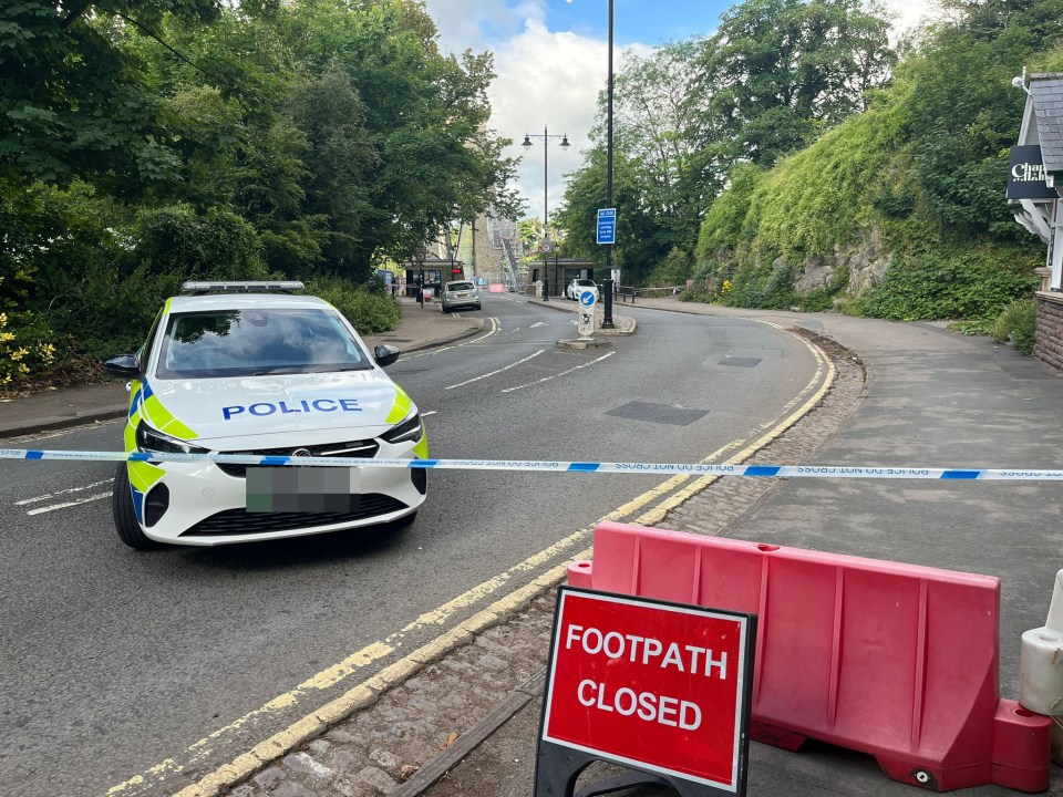 a police car is parked behind a red sign that says footpath closed